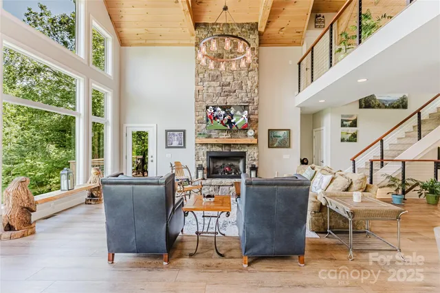 a living room with fireplace furniture and a large window