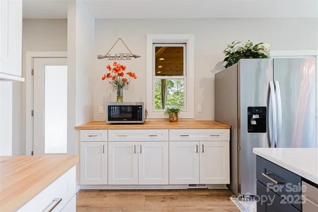 a living room with stainless steel appliances kitchen island granite countertop a refrigerator and a stove