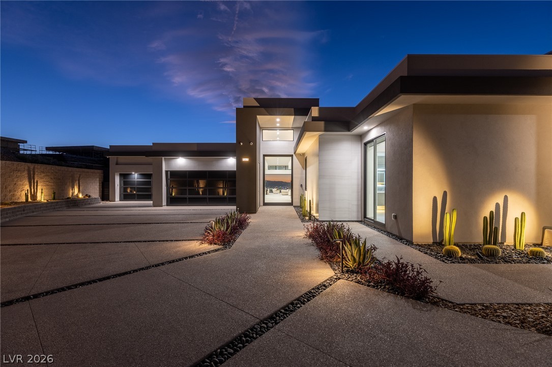 563 Grand Rim Drive Henderson, NV 89012 - Photo 42 of 70 A modern architectural marvel, showcasing a striking exterior with a grand entrance and well-manicured desert landscaping.