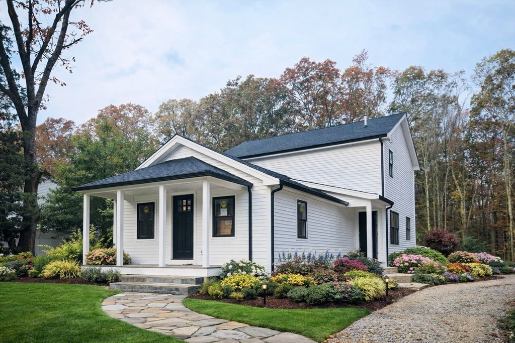 a front view of a house with a yard outdoor seating and mountain view