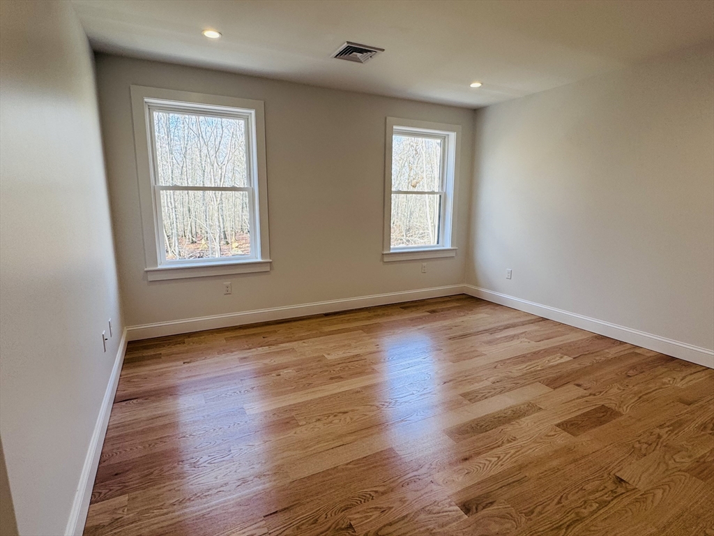 329 Tickle Road Westport, MA 02790 - Photo 34 of 42 an empty room with wooden floor and windows