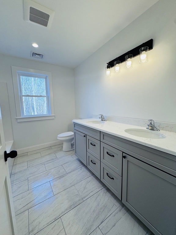329 Tickle Road Westport, MA 02790 - Photo 39 of 42 a spacious bathroom with a granite countertop sink a toilet and a mirror
