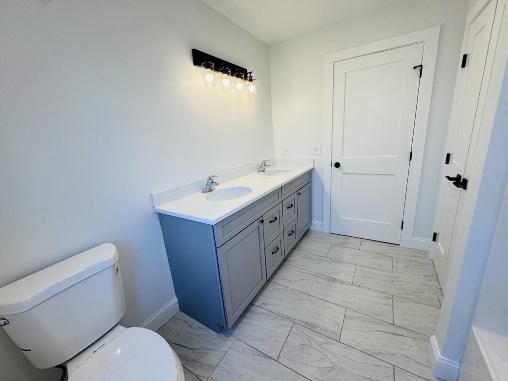 329 Tickle Road Westport, MA 02790 - Photo 40 of 42 a bathroom with a toilet sink and mirror