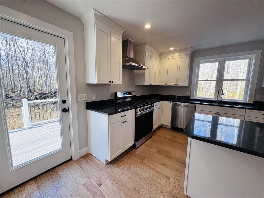 329 Tickle Road Westport, MA 02790 - Photo 8 of 42 a kitchen with granite countertop wooden floors and white stainless steel appliances
