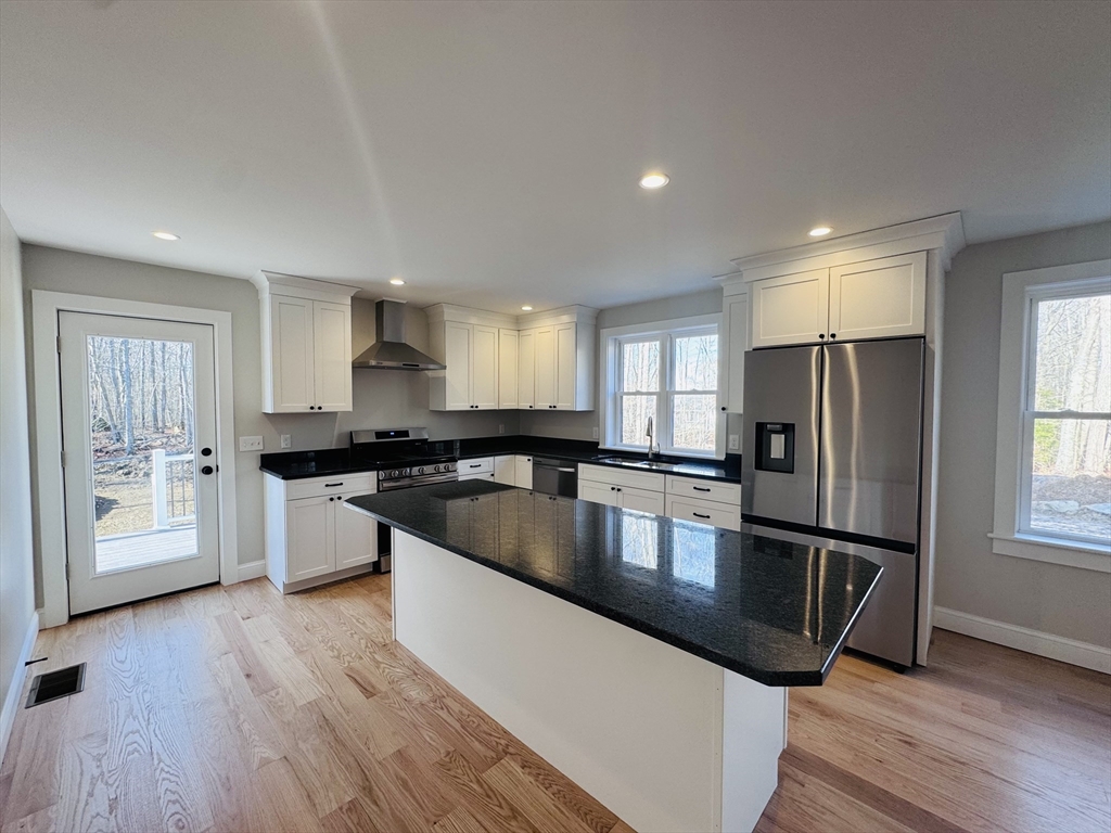 329 Tickle Road Westport, MA 02790 - Photo 9 of 42 a large kitchen with stainless steel appliances granite countertop a refrigerator a sink a stove and wooden floors