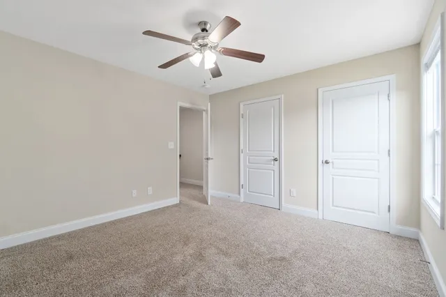 an empty room with chandelier fan