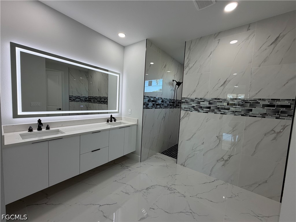112 Northeast 6th Street Cape Coral, FL 33909 - Photo 11 of 37 a large bathroom with a sink and a large mirror