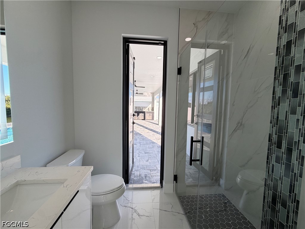 112 Northeast 6th Street Cape Coral, FL 33909 - Photo 21 of 37 a bathroom with a granite countertop shower a toilet and a sink
