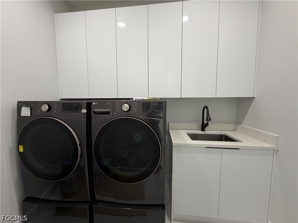 112 Northeast 6th Street Cape Coral, FL 33909 - Photo 24 of 37 a view of cabinets and washer dryer