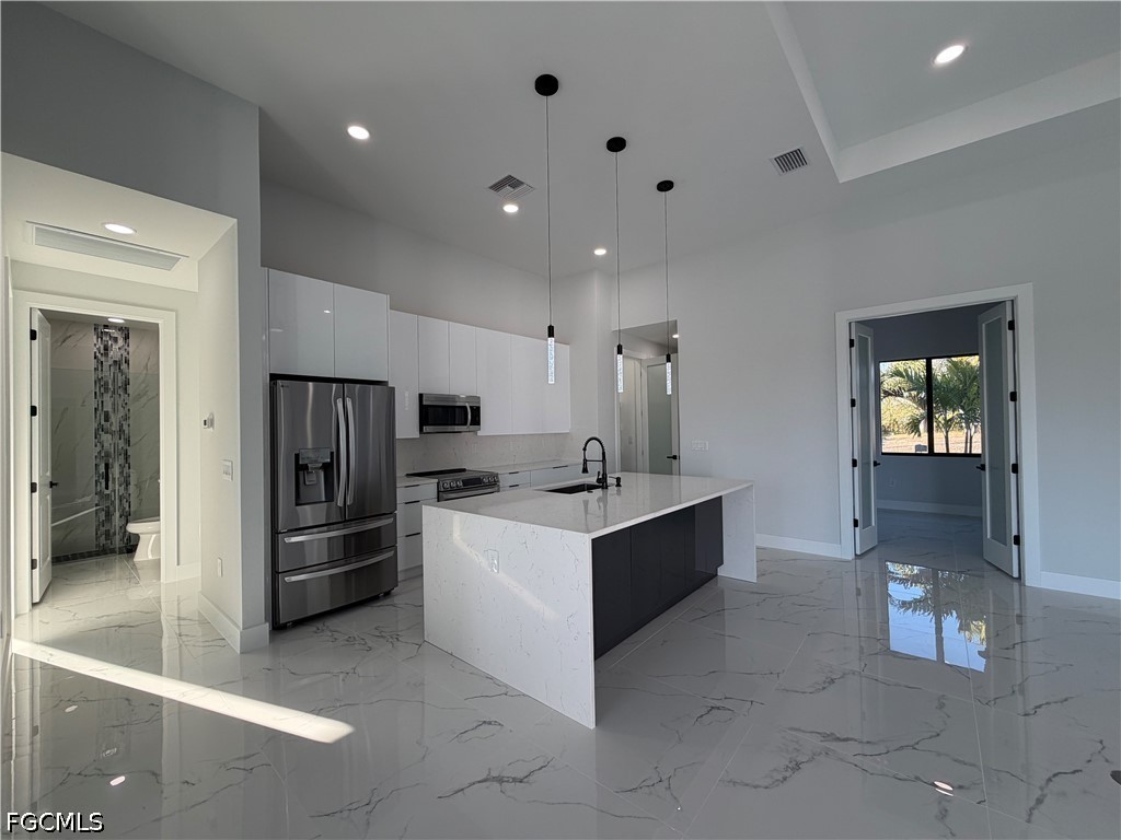 112 Northeast 6th Street Cape Coral, FL 33909 - Photo 7 of 37 a kitchen with refrigerator and cabinets