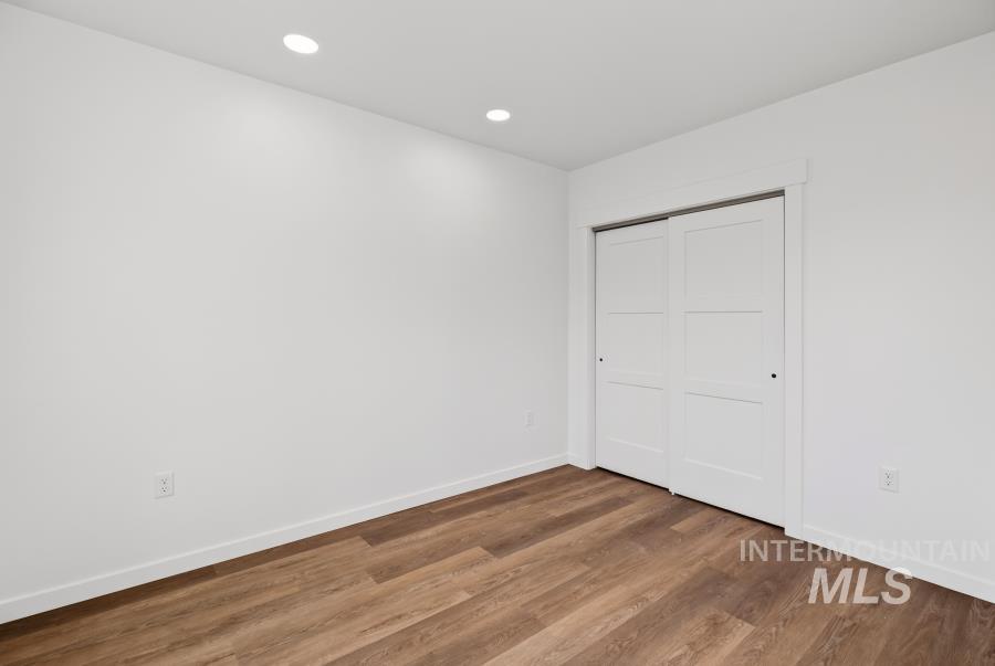 1298 Edington Moscow, ID 83843 - Photo 30 of 32 Wood-finish flooring with white baseboards, recessed ceiling lighting, and sliding white closet doors