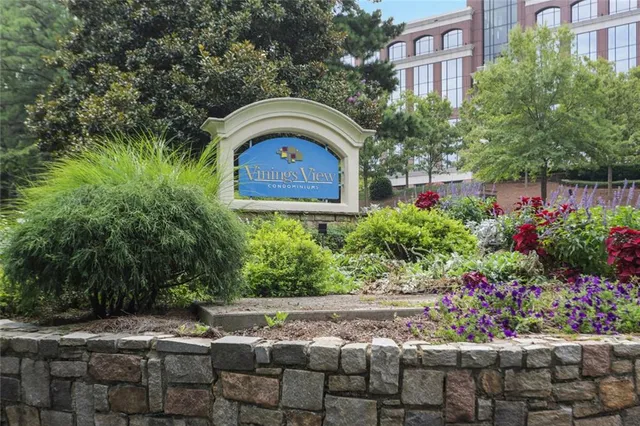 a front view of house and yard with beautiful flowers and green space
