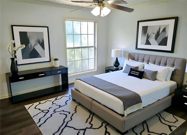 a bedroom with a bed and a painting on the wall