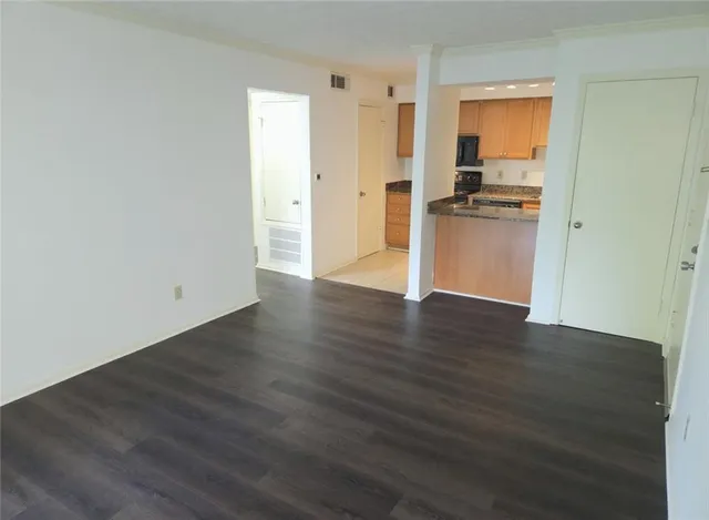 a view of empty room with wooden floor