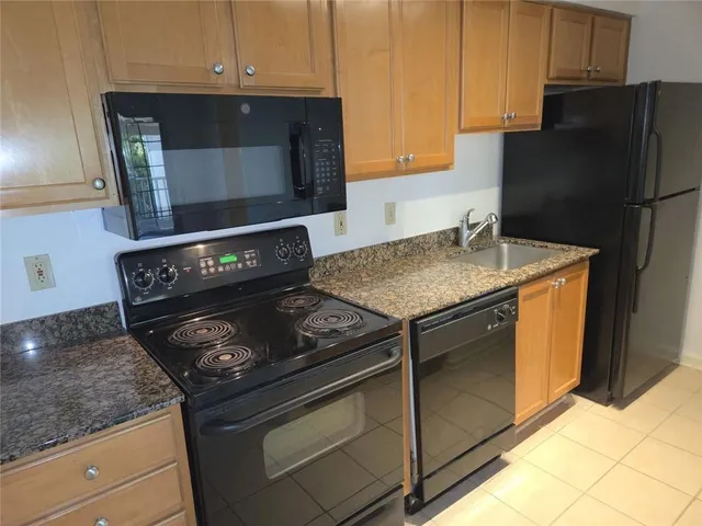 a kitchen with granite countertop a stove and a microwave