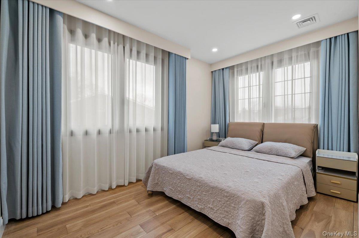 2 Elf Road Syosset, NY 11791 - Photo 16 of 38 a spacious bedroom with a large bed and a large window