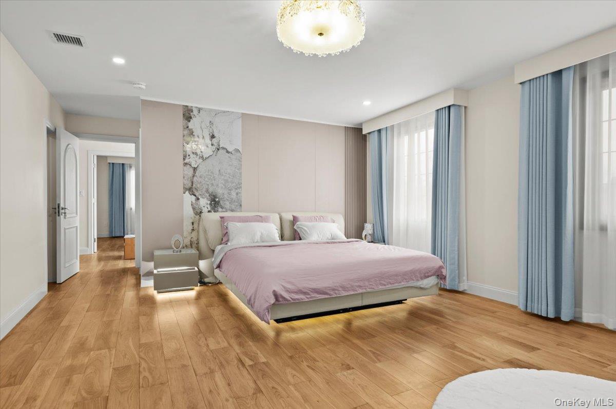 2 Elf Road Syosset, NY 11791 - Photo 23 of 38 a bedroom with a bed and a chandelier