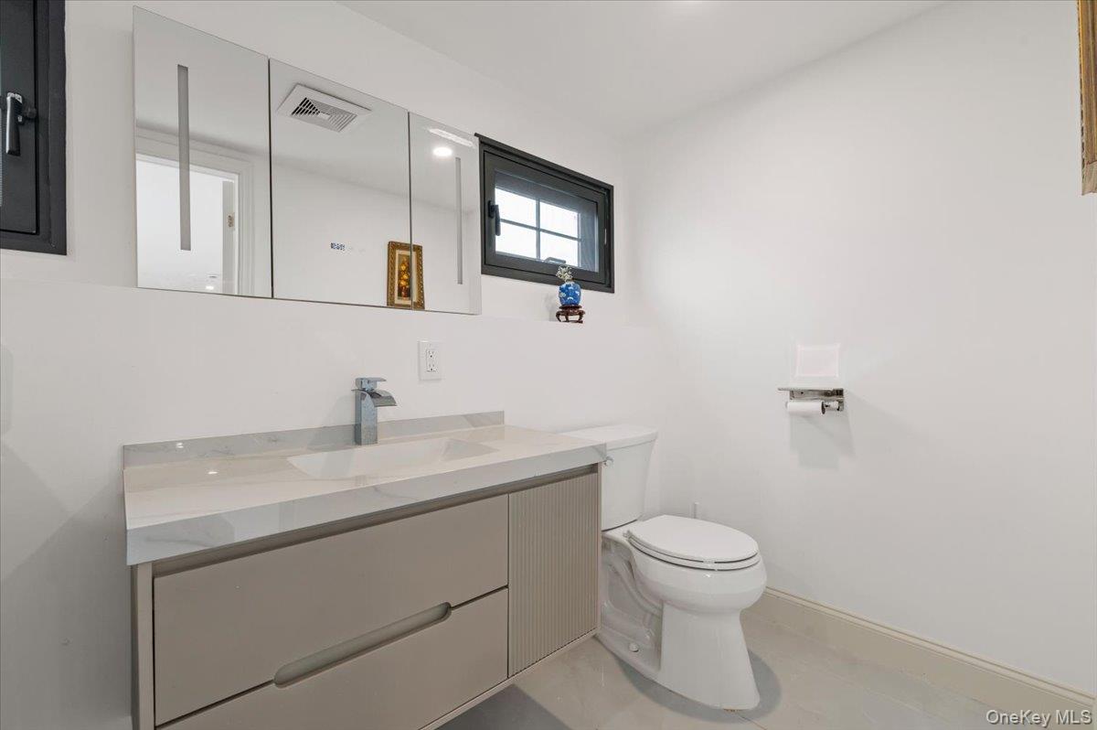 2 Elf Road Syosset, NY 11791 - Photo 31 of 38 a bathroom with a toilet a sink and mirror