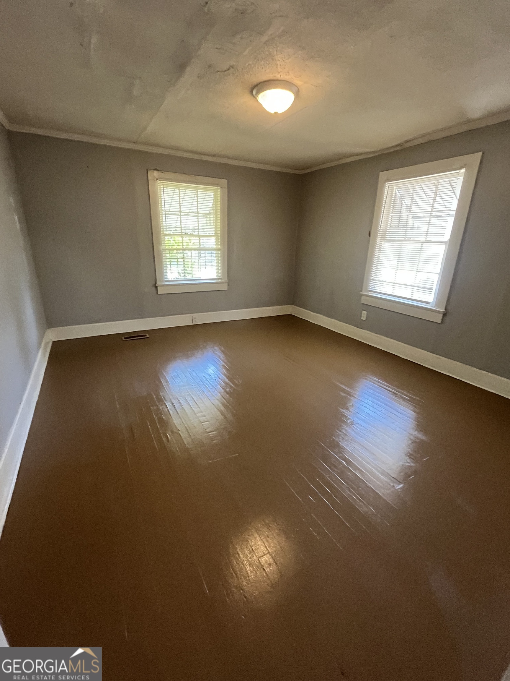 3423 Flamingo Drive Macon, GA 31206 - Photo 5 of 6 an empty room with wooden floor and windows