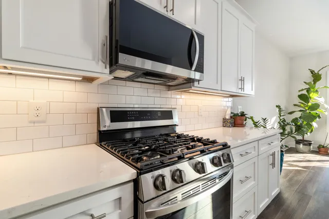 a stove top oven sitting inside of a kitchen