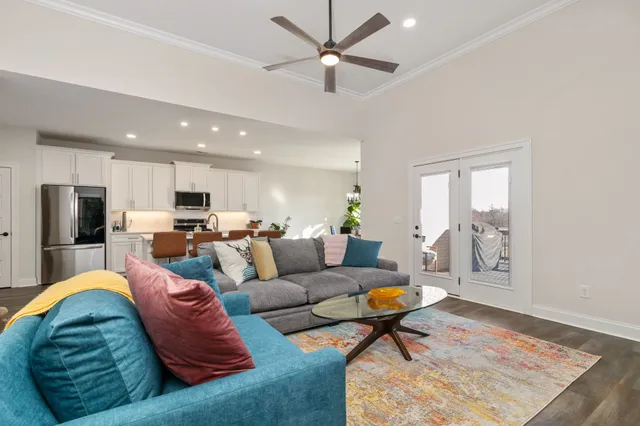 a living room with furniture kitchen view and a window