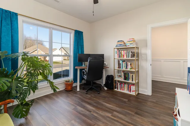 a living room with furniture floor to ceiling window and wooden floor