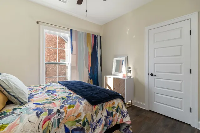 a bedroom with a large bed and a wooden floor