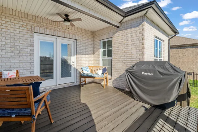 a view of a patio with table and chairs and barbeque with wooden floor
