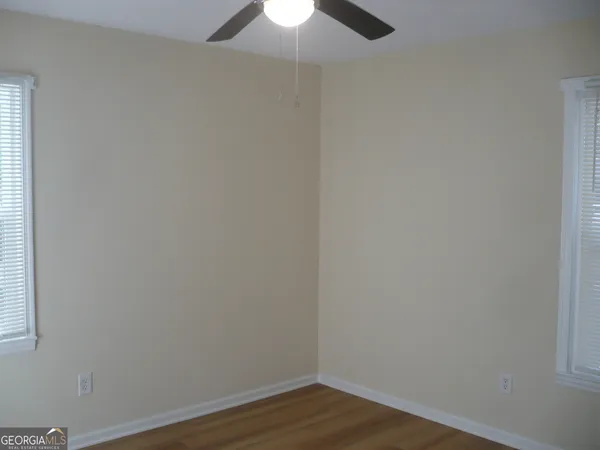 a view of a small space with wooden floor fan and a window