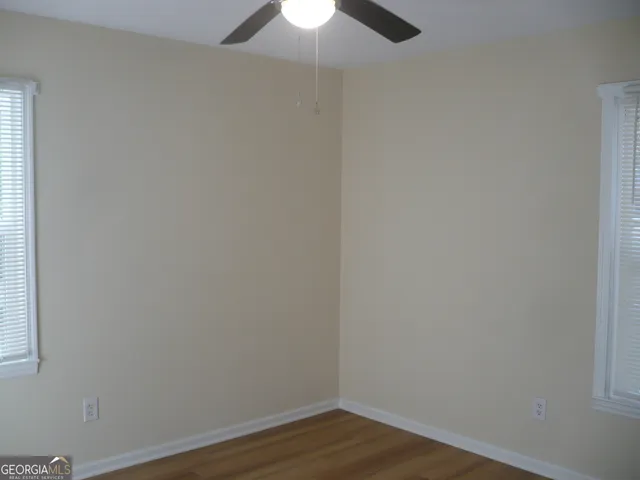 a view of a small space with wooden floor fan and a window