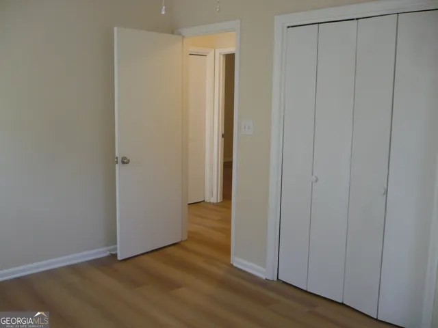 a view of an empty room with wooden floor