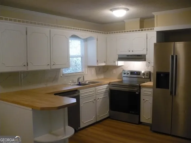 a kitchen with a sink stove and refrigerator