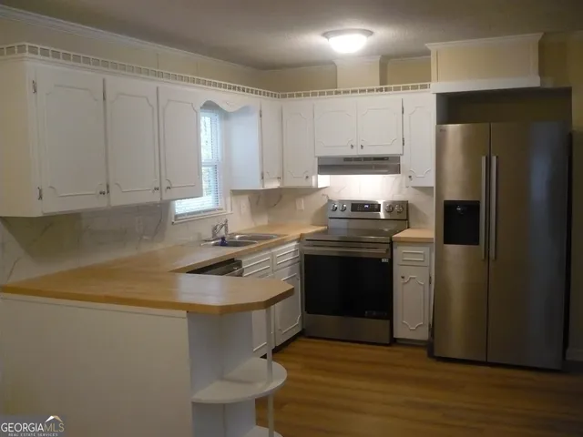 a kitchen with a sink appliances and cabinets