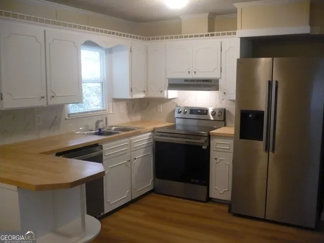 a kitchen with a sink appliances and cabinets