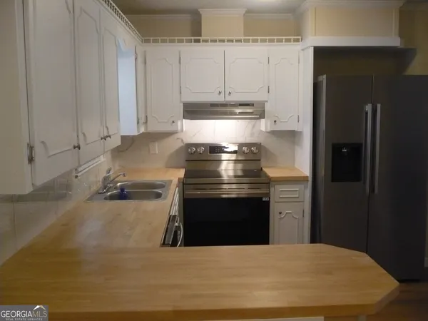 a kitchen with stainless steel appliances granite countertop a stove a refrigerator and a sink