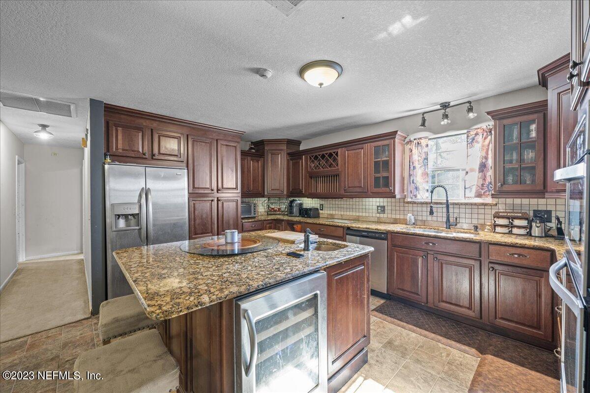 7145 Fitzpatrick Lane Jacksonville, FL 32226 - Photo 22 of 42 a kitchen with stainless steel appliances granite countertop a sink stove and refrigerator