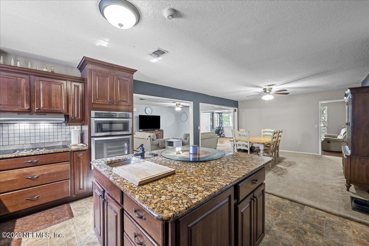 7145 Fitzpatrick Lane Jacksonville, FL 32226 - Photo 24 of 42 a kitchen with granite countertop a sink and stove