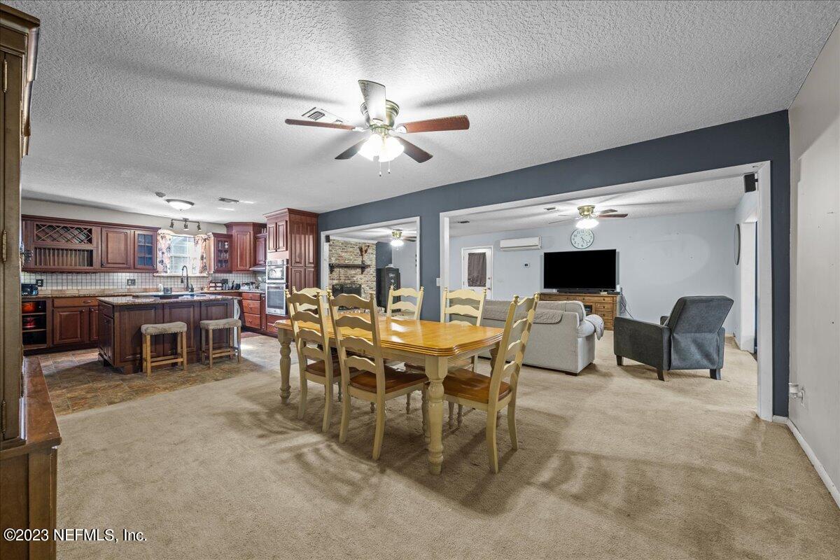 7145 Fitzpatrick Lane Jacksonville, FL 32226 - Photo 25 of 42 a view of a dining room with furniture and a flat screen tv