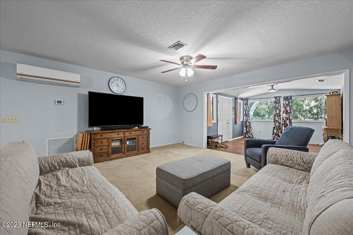 7145 Fitzpatrick Lane Jacksonville, FL 32226 - Photo 29 of 42 a living room with furniture and a flat screen tv