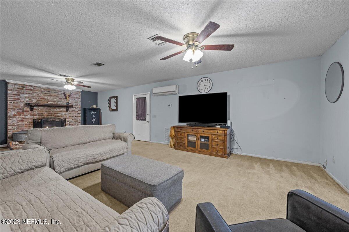 7145 Fitzpatrick Lane Jacksonville, FL 32226 - Photo 30 of 42 a living room with furniture and a flat screen tv