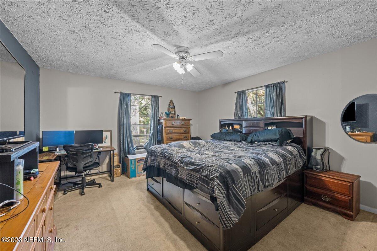 7145 Fitzpatrick Lane Jacksonville, FL 32226 - Photo 35 of 42 a bedroom with a bed a table and chair