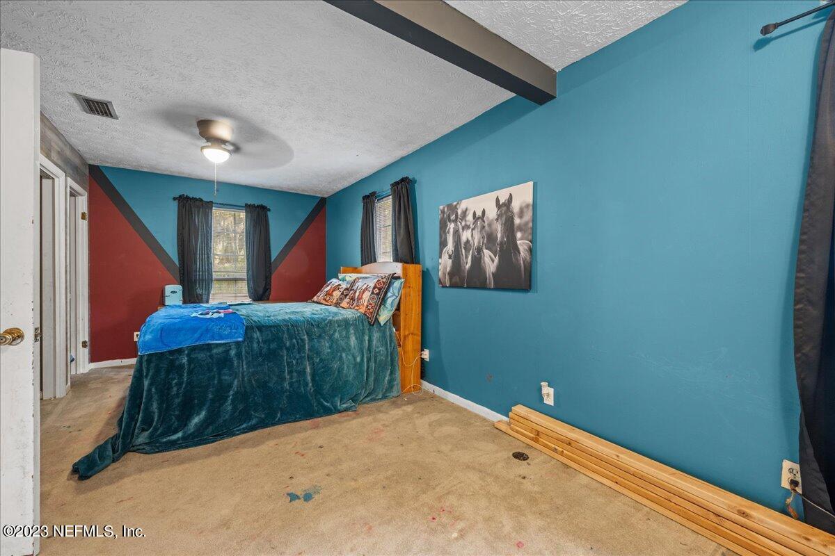 7145 Fitzpatrick Lane Jacksonville, FL 32226 - Photo 36 of 42 a bedroom with a large bed and a dresser