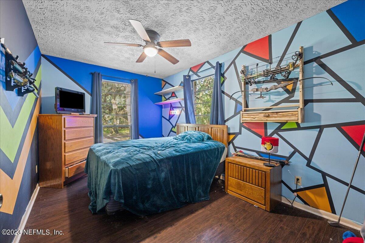 7145 Fitzpatrick Lane Jacksonville, FL 32226 - Photo 38 of 42 a bedroom with a bed and wooden floor