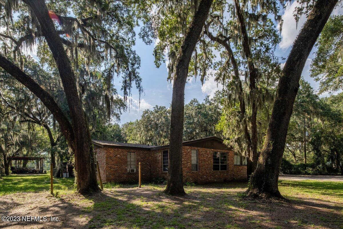 7145 Fitzpatrick Lane Jacksonville, FL 32226 - Photo 4 of 42 a front view of a house with a yard and large trees