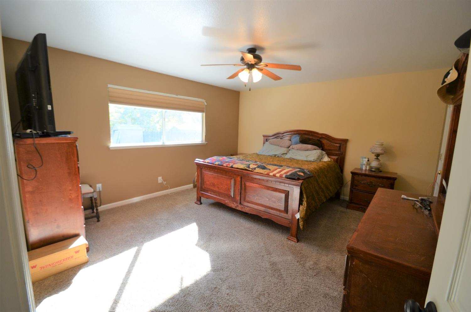 7453 Live Oak Drive Sanger, CA 93657 - Photo 16 of 28 a bedroom with a bed and a chandelier