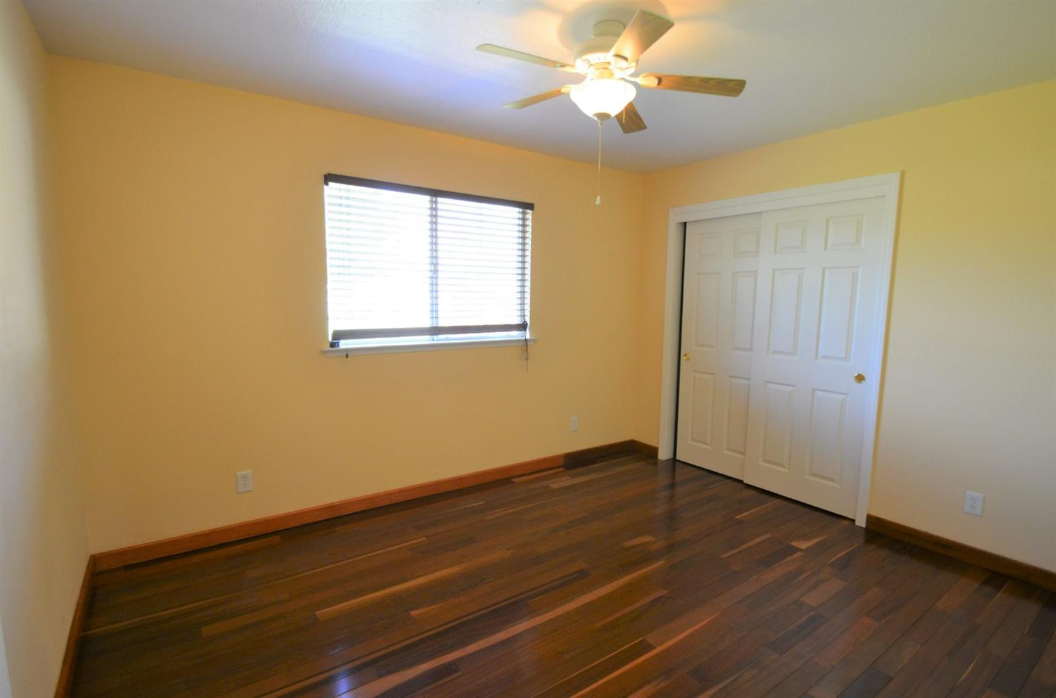 7453 Live Oak Drive Sanger, CA 93657 - Photo 20 of 28 a view of an empty room with wooden floor and a window