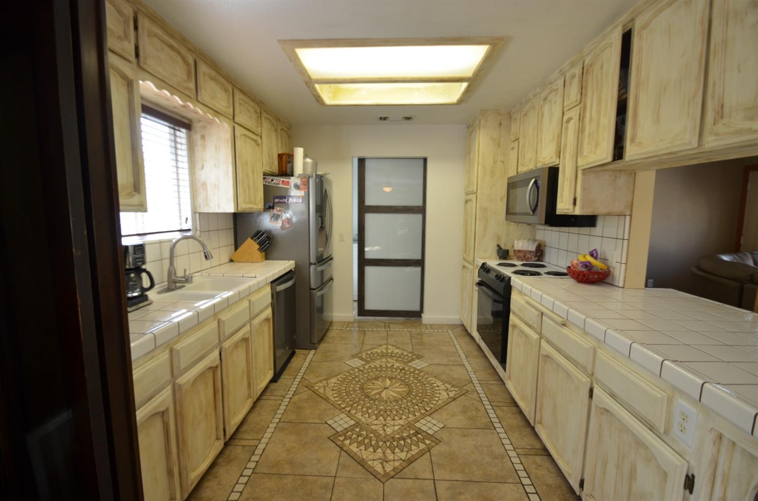 7453 Live Oak Drive Sanger, CA 93657 - Photo 6 of 28 a large kitchen with a stove a sink dishwasher and a refrigerator