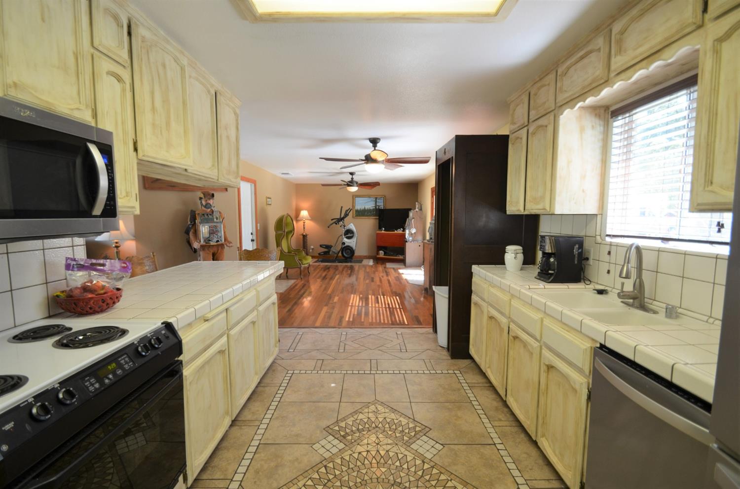 7453 Live Oak Drive Sanger, CA 93657 - Photo 7 of 28 a large kitchen with stainless steel appliances granite countertop a stove a sink dishwasher and a microwave oven with large cabinets