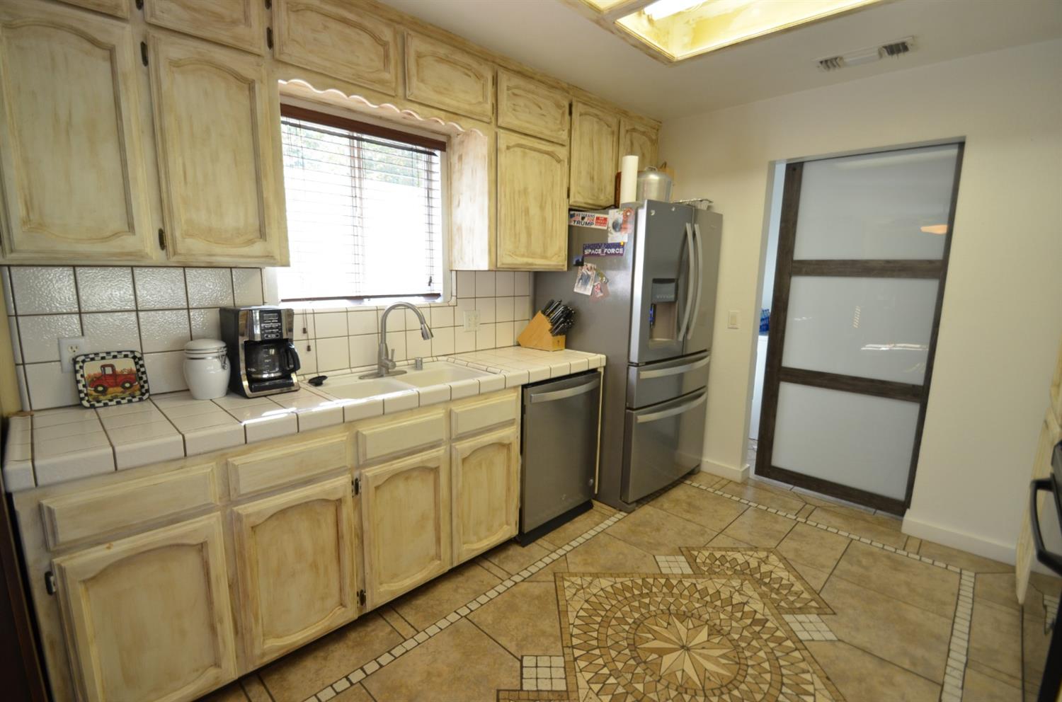 7453 Live Oak Drive Sanger, CA 93657 - Photo 8 of 28 a kitchen with stainless steel appliances a refrigerator sink and cabinets