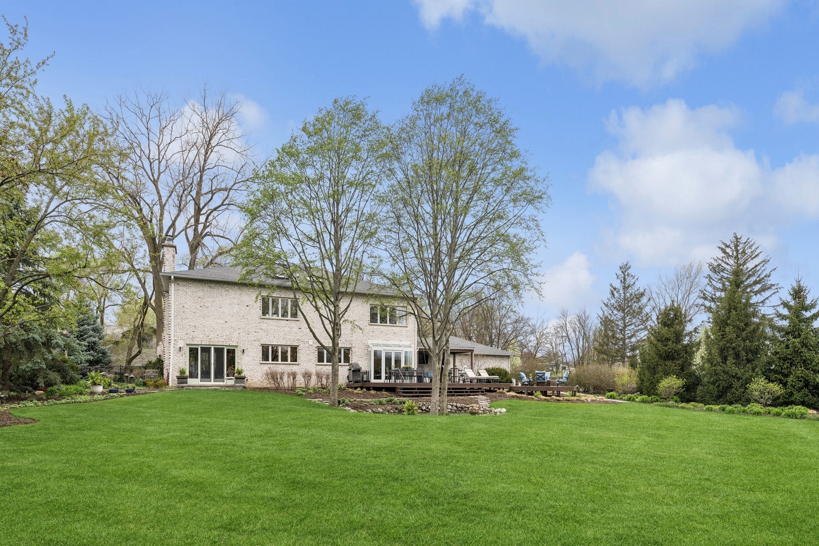 3606 Lawson Road Glenview, IL 60026 - Photo 55 of 62 a backyard of a house with table and chairs plants and large tree